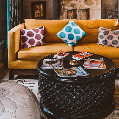 A modern style living room with a pumpkin coloured sofa with magazines and coffee table