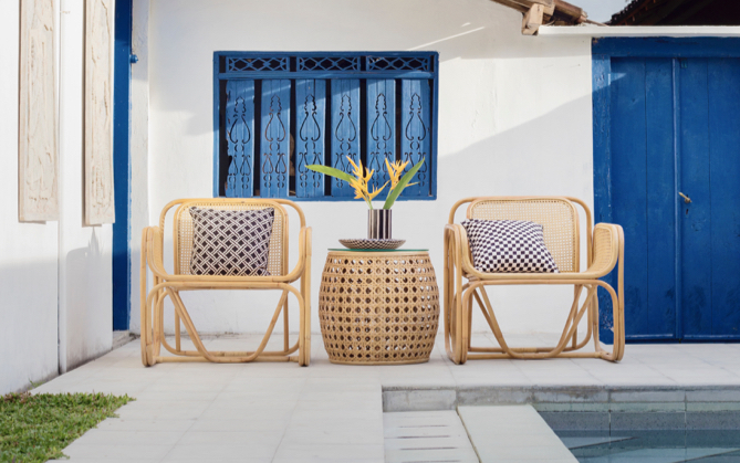 Two poolside chairs sitting against a back wall